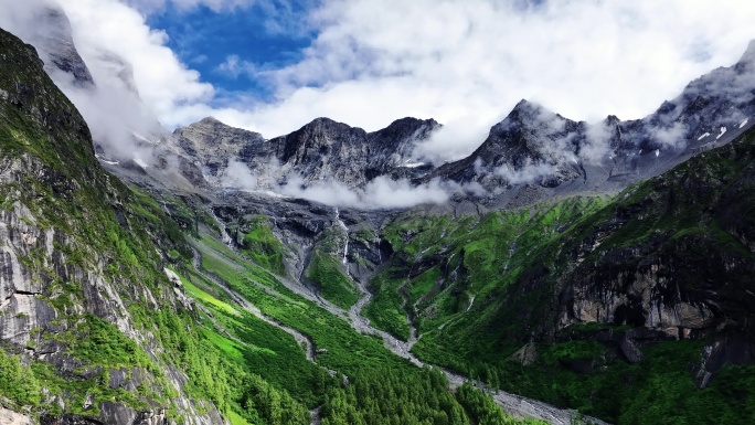 航拍蓝天白云下四姑娘山的群峰和山谷