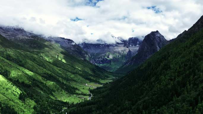 航拍蓝天白云下四姑娘山的群峰和山谷
