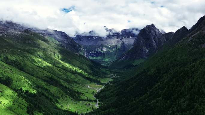 航拍蓝天白云下四姑娘山的群峰和山谷
