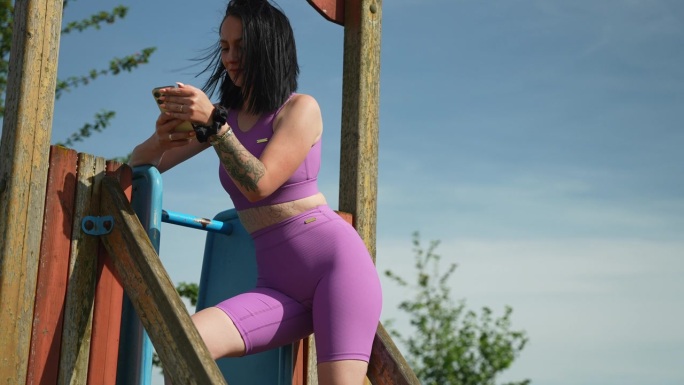 年轻女子在游乐场设备上摆姿势