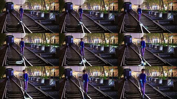 男孩在铁路轨道上走，手持手电筒，4K。