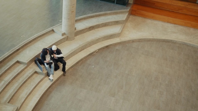 两名大学生热切地合作他们的团队项目，充满热情地交流创意想法。