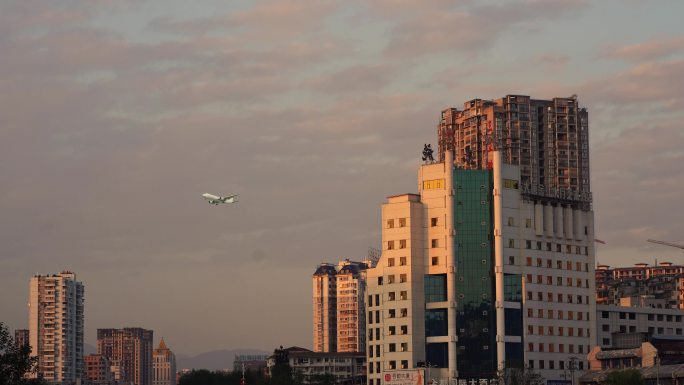 黄昏天空下的城市建筑与飞机