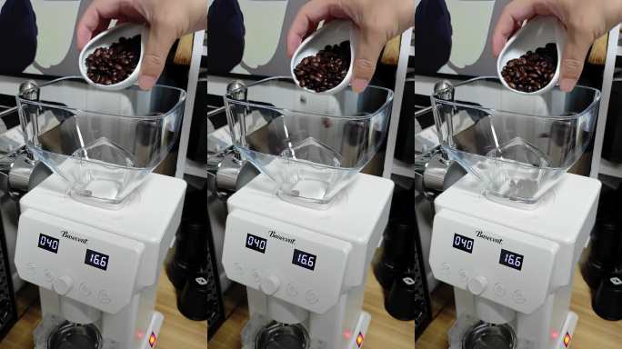 咖啡豆倒入研磨机特写