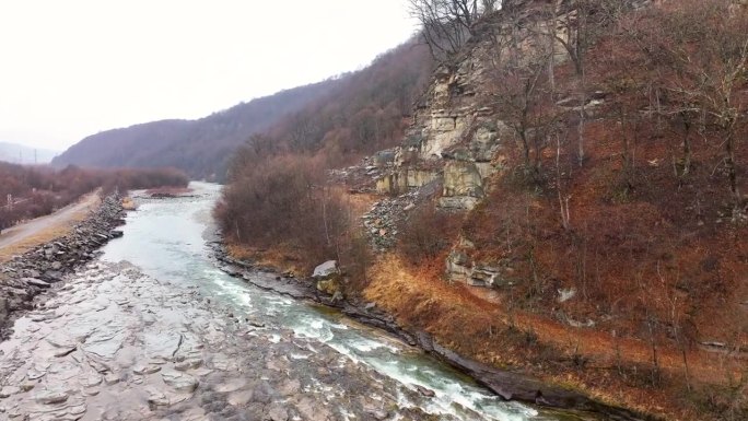 航拍视角，快速流淌的山间河流与崎岖的岩石河岸