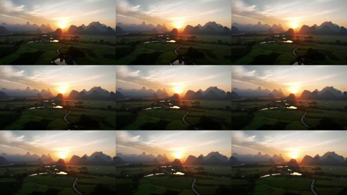 航拍日出时分桂林喀斯特山峰和绿色稻田