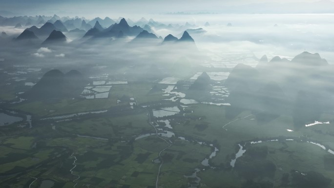航拍日出云雾缭绕下喀斯特地貌稻田风光