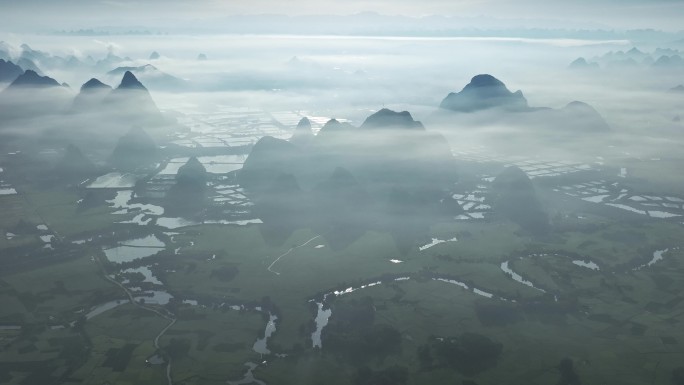 航拍日出云雾缭绕下喀斯特地貌稻田风光
