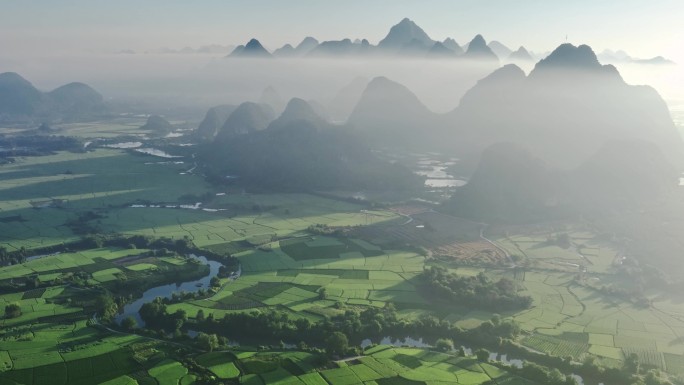 航拍日出云雾缭绕下喀斯特地貌稻田风光