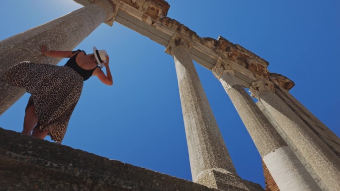 女人在阿尔巴尼亚的阿波罗尼亚探索古老的遗迹，背景是天空。