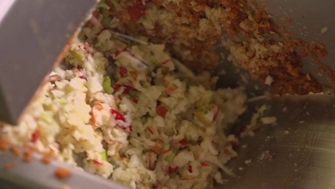 工业压碎机内的切碎苹果和水果块，用于果汁生产。在现代食品制造厂中，原料混合物在压榨前进行处理。