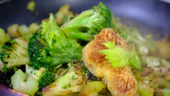 美味的炒面包鸡肉配蔬菜，西兰花，芹菜在铸铁锅中蒸煮，烹饪过程，健康餐。