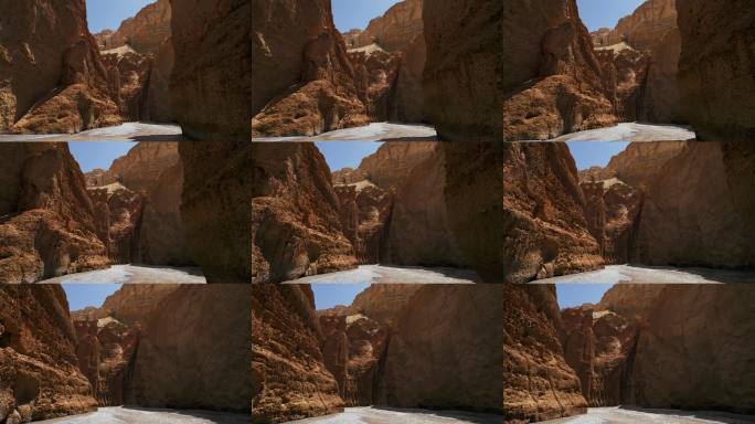 一架无人机低飞穿过尼泊尔的狭窄峡谷，水流在高耸悬崖的底部流淌。