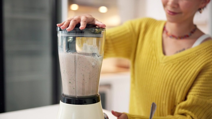 女人在厨房台面上制作冰沙，用于早餐、肠道健康或消化支持。健康的食物、均衡的饮食或在家中使用机器、营养