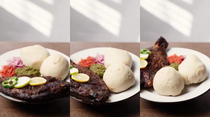 竖屏视频，班库，玉米木薯发酵面团配烤罗非鱼和辣椒酱，来自西非的传统加纳菜肴