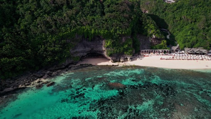 镜头从巴厘岛梅拉斯蒂海滩的金色沙滩、绿色悬崖和珊瑚遍布的浅海飞掠而过，展现出一片宁静的热带海岸天堂。
