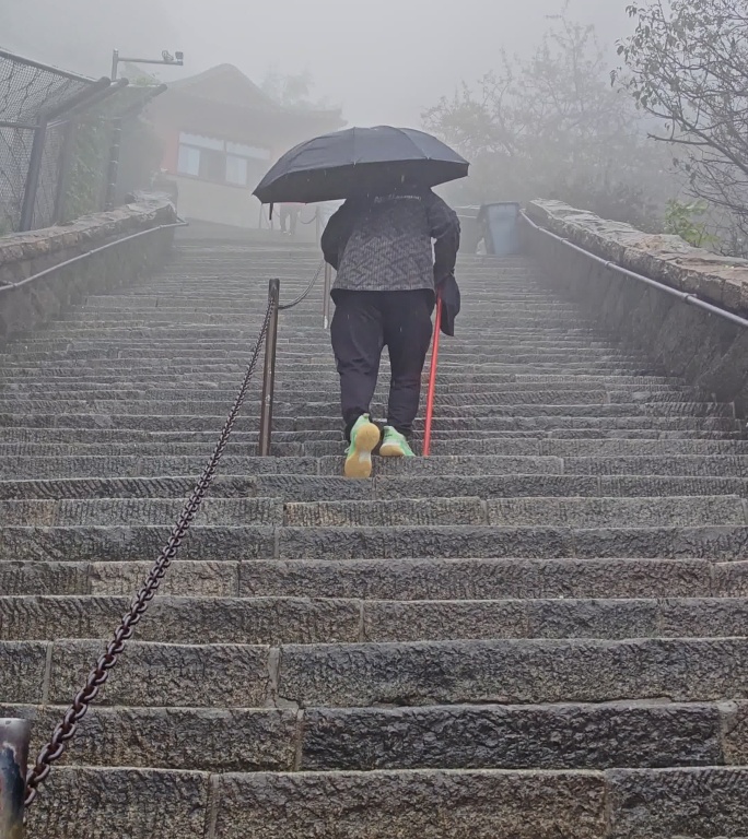 雾中登山者攀登石阶
