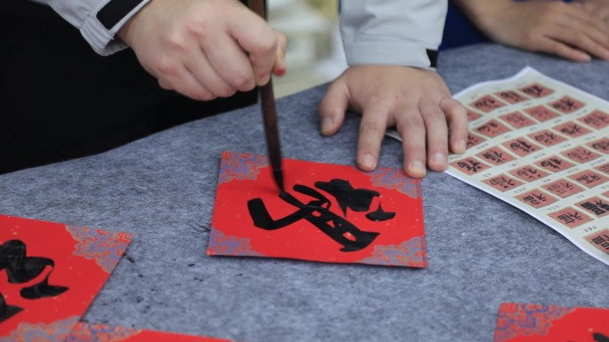 老师教同学们写毛笔字福字春联