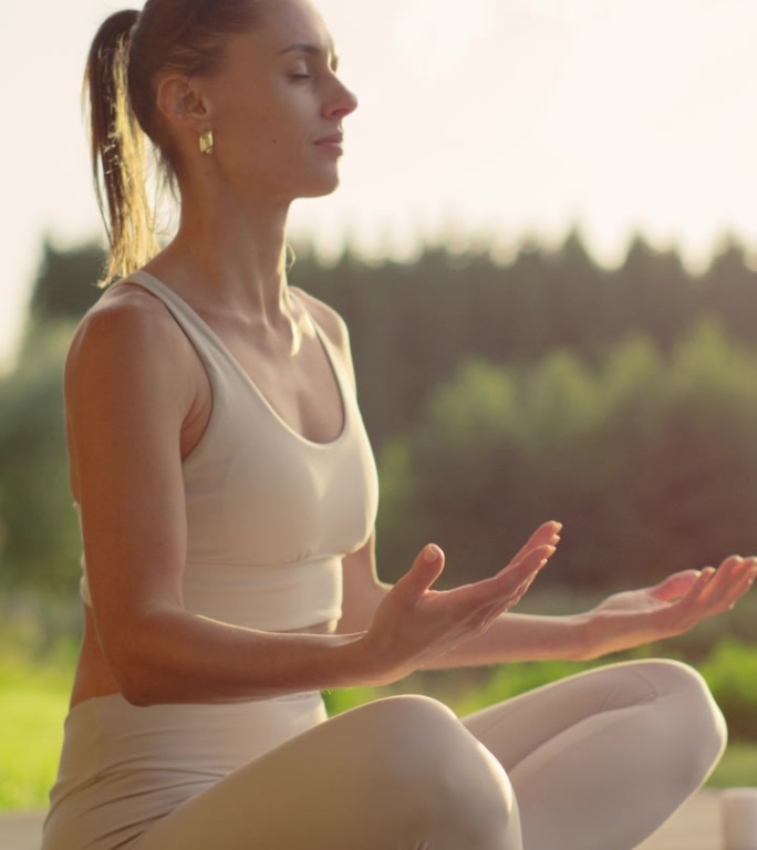 竖屏：女人在阳台上冥想。香气四溢的香熏和轻柔的唱碗声增强了宁静的氛围，让她能够专注并与自己的修行连接