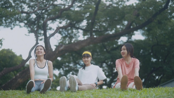 朋友们各种风格的人聚在一起，晨练后在公园里坐下来聊天和放松。