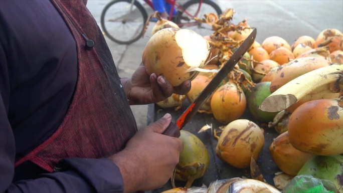特写镜头，椰子卖家正在切椰子。独特卖点