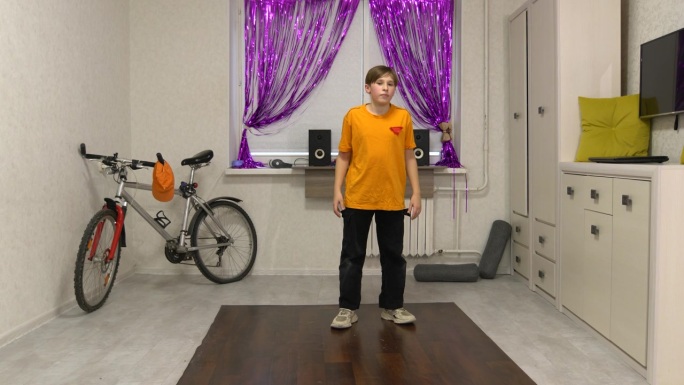 一个少年在他装饰有自行车的房间里学习霹雳舞。