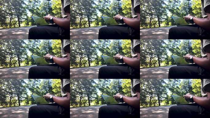 在公园里，靠近马路的地方，一位自由职业者正坐在笔记本电脑前，享受着美好的日子。