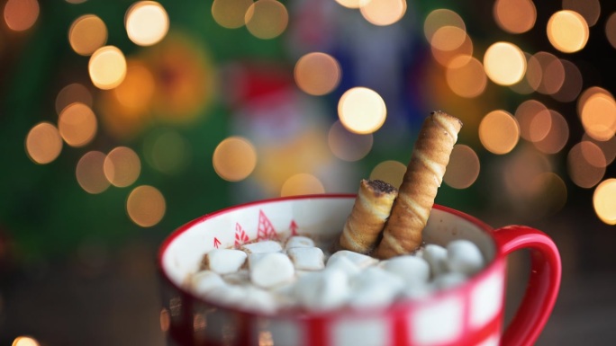 在节日木质背景上加热的含棉花糖和威化饼干的热巧克力