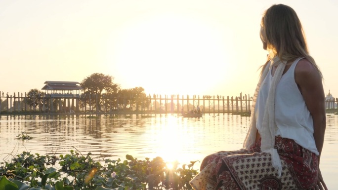 女人在湖边享受宁静的日落。