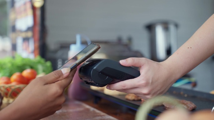 食品车摊贩为一位未识别的非洲年轻顾客提供新鲜制作的汉堡。