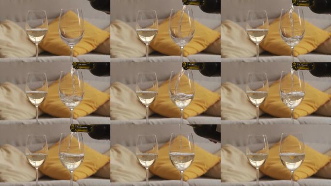 端上两杯白葡萄酒，背景是模糊的靠垫。