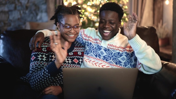 快乐的情侣在节日的晚上一起享受假期视频聊天。