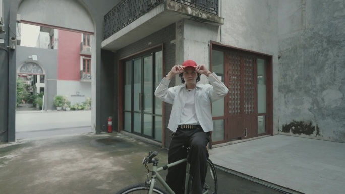 充满活力的亚洲男性成年人在白天的城市道路上骑自行车，展示日常生活。