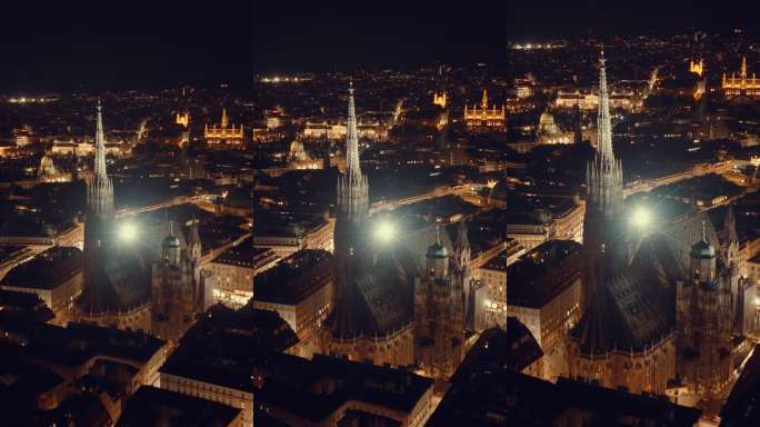 航拍无人机镜头：夜间圣斯蒂芬大教堂及灯火辉煌的维也纳城市景观