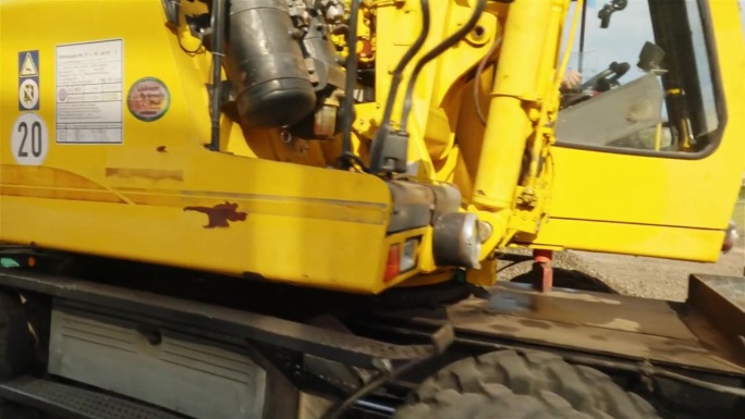 挖掘机在修复火车轨道后，从货运车厢卸下碎石。无人机视角