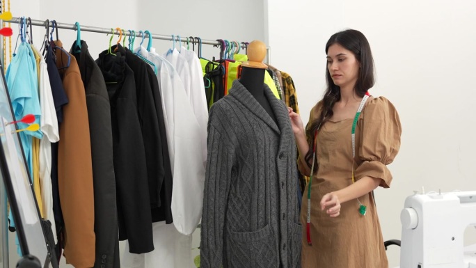 4K视频：设计师检查和缝制一件服装。