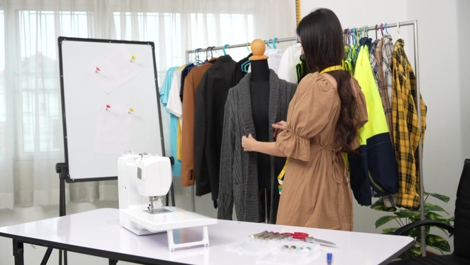 4K视频：设计师检查和缝制服装。