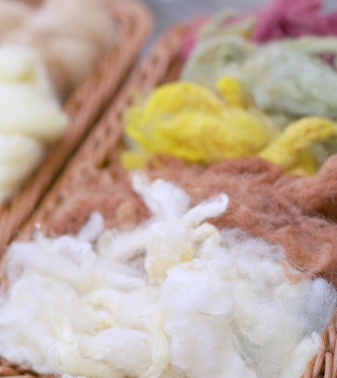 柳条筐中的天然羊毛纤维和纱线